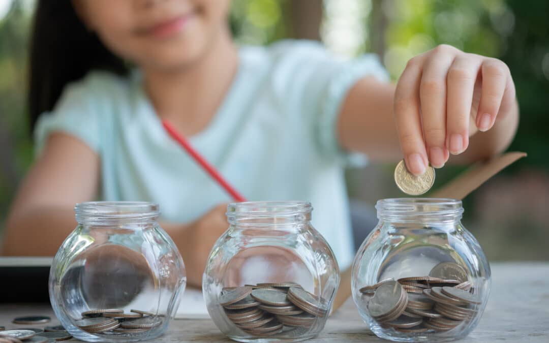 Girl adding coins to a small jar