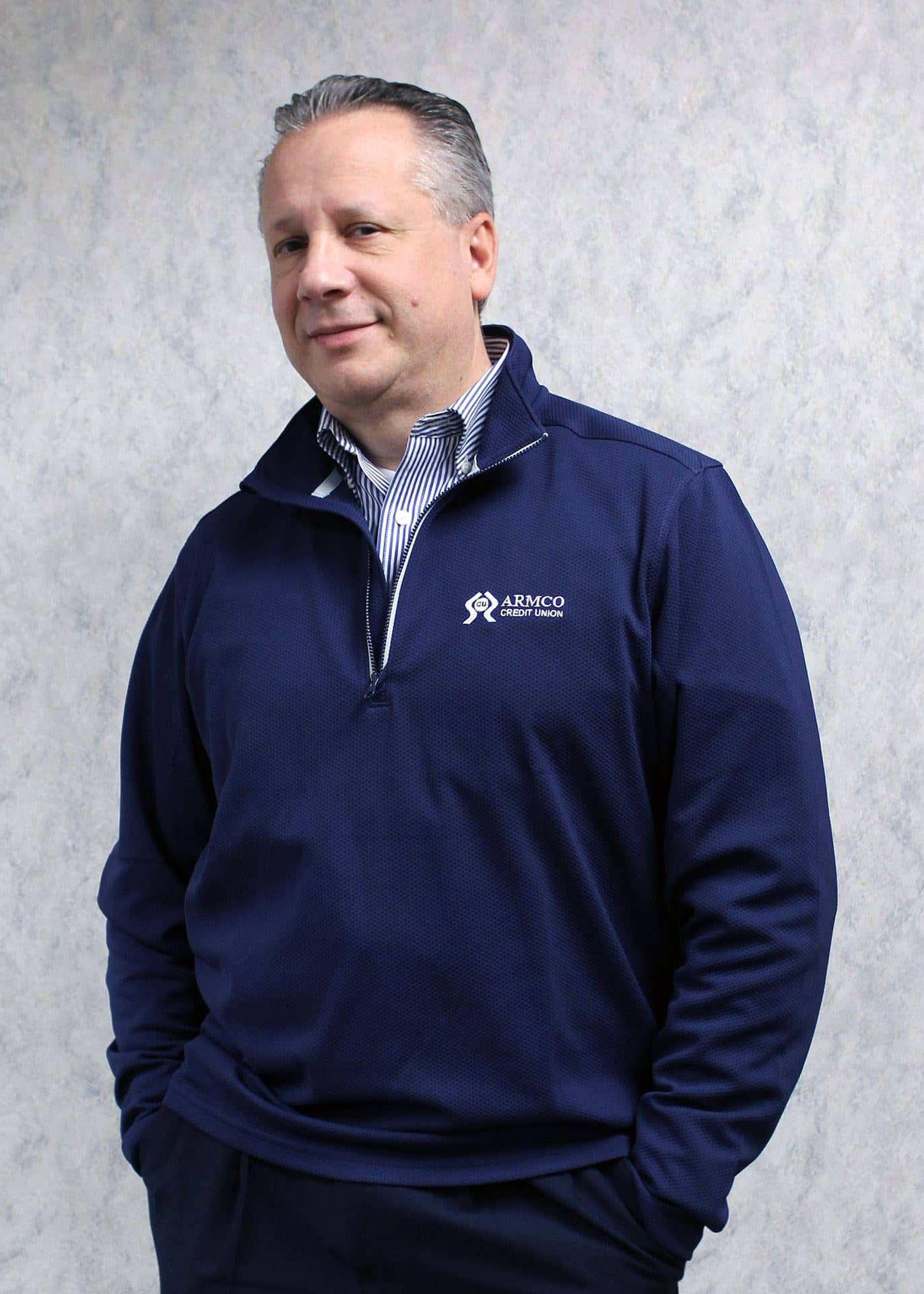 A man wearing the navy Armco CU quarter zip jacket.